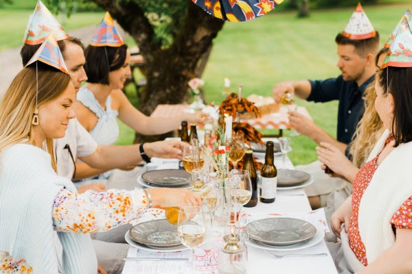 Kräftskiva, de Zweedse traditie van de nazomer.  Families, vrienden en gasten verzamelen zich aan lange tafels met schalen vol rivierkreeft, Västerbottenkaas, knäckebröd en schnaps, lampionnen en papieren feesthoedjes.